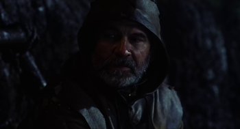 Movie still from “Henry V” (1989), directed by Kenneth Branagh – A man with a gray beard wearing a black hooded jacket; Close Up shot, Low angle