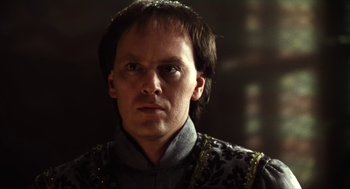 Movie still from “Henry V” (1989), directed by Kenneth Branagh – A person wearing a suit and tie; Close Up shot, Over the shoulder angle