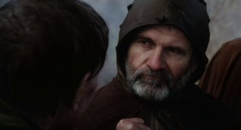 Movie still from “Henry V” (1989), directed by Kenneth Branagh – An older man wearing a hood looking into a mirror; Close Up shot, Over the shoulder angle