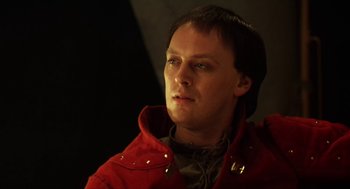 Movie still from “Henry V” (1989), directed by Kenneth Branagh – A man in a red jacket looking to his left; Close Up shot, Low angle