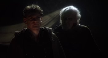 Movie still from “Henry V” (1989), directed by Kenneth Branagh – A man standing next to another man on a train track; Close Up shot, Over the shoulder angle