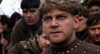 Movie still from “Henry V” (1989), directed by Kenneth Branagh – A person wearing a leather jacket; Close Up shot, Low angle