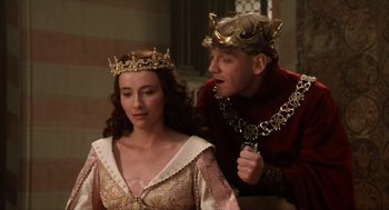 Movie still from “Henry V” (1989), directed by Kenneth Branagh – A man and a woman wearing gold crowns; Medium shot, Over the shoulder angle