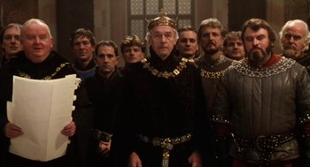 Movie still from “Henry V” (1989), directed by Kenneth Branagh – A group of men standing next to each other in medieval garb; Medium shot, Low angle