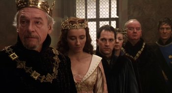 Movie still from “Henry V” (1989), directed by Kenneth Branagh – A group of people standing next to each other wearing crowns; Medium shot, High angle