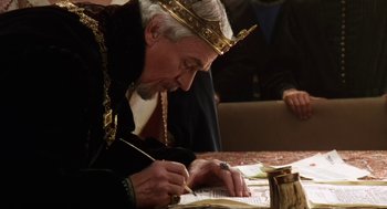 Movie still from “Henry V” (1989), directed by Kenneth Branagh – An old man wearing a crown writing on a piece of paper; Close Up shot, Over the shoulder angle