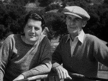 Movie still from “Here Comes Mr. Jordan” (1941), directed by Alexander Hall – An older man sitting next to an older woman on a park bench; Medium shot, Low angle