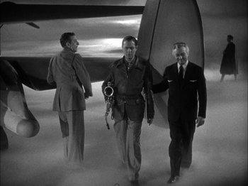 Movie still from “Here Comes Mr. Jordan” (1941), directed by Alexander Hall – A black - and - white photo of three men in suits walking through the clouds; Wide shot, Low angle