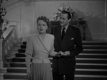 Movie still from “Here Comes Mr. Jordan” (1941), directed by Alexander Hall – A man and a woman standing next to each other in front of a staircase; Medium shot, Low angle