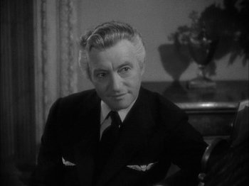 Movie still from “Here Comes Mr. Jordan” (1941), directed by Alexander Hall – An old black and white photo of a man in a suit; Close Up shot, High angle
