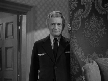 Movie still from “Here Comes Mr. Jordan” (1941), directed by Alexander Hall – An older man wearing a suit and tie in front of a wall; Medium shot, Low angle