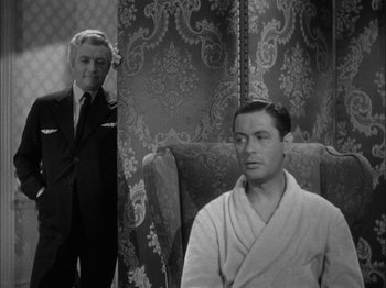 Movie still from “Here Comes Mr. Jordan” (1941), directed by Alexander Hall – A man in a suit standing next to another man in a robe; Medium shot, Over the shoulder angle
