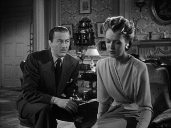 Movie still from “Here Comes Mr. Jordan” (1941), directed by Alexander Hall – An older man and a younger woman sitting in a living room; Medium shot, Low angle