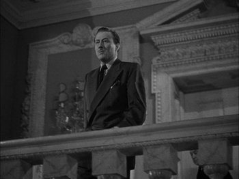 Movie still from “Here Comes Mr. Jordan” (1941), directed by Alexander Hall – A black and white photo of a man in a suit and tie; Medium shot, Low angle