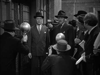 Movie still from “Here Comes Mr. Jordan” (1941), directed by Alexander Hall – A black and white photo of a group of men in hats; Medium shot, Low angle