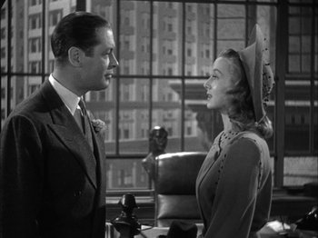Movie still from “Here Comes Mr. Jordan” (1941), directed by Alexander Hall – A man and a woman standing next to each other; Medium shot, Low angle