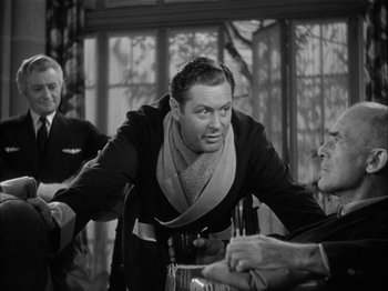 Movie still from “Here Comes Mr. Jordan” (1941), directed by Alexander Hall – An old photo of a man with a scarf around his neck; Medium shot, Over the shoulder angle