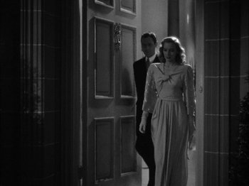 Movie still from “Here Comes Mr. Jordan” (1941), directed by Alexander Hall – A man and a woman are walking through a door way; Medium shot, High angle