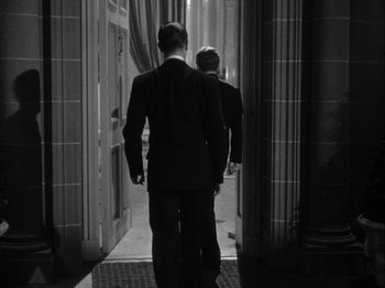 Movie still from “Here Comes Mr. Jordan” (1941), directed by Alexander Hall – A man and a woman walking down a hall way; Medium shot, Over the shoulder angle