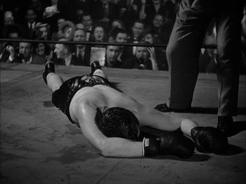Movie still from “Here Comes Mr. Jordan” (1941), directed by Alexander Hall – A man laying on the ground in a boxing ring; Medium shot, High angle
