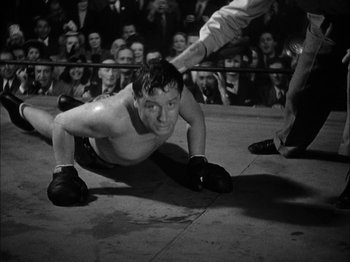 Movie still from “Here Comes Mr. Jordan” (1941), directed by Alexander Hall – A black and white photo of a man in a boxing ring; Medium shot, High angle
