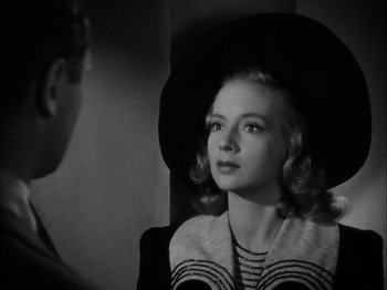 Movie still from “Here Comes Mr. Jordan” (1941), directed by Alexander Hall – A young woman wearing a hat looking into a mirror; Close Up shot, Over the shoulder angle