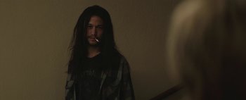 Movie still from “Hesher” (2010), directed by Spencer Susser – A man with long hair is smoking a cigarette; Medium shot, Low angle