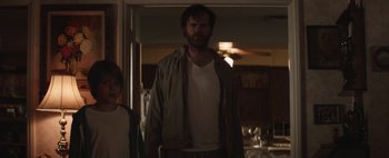 Movie still from “Hesher” (2010), directed by Spencer Susser – A man and a woman standing in front of a doorway; Medium shot, Low angle