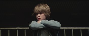 Movie still from “Hesher” (2010), directed by Spencer Susser – A young boy with his arms folded around his chest; Close Up shot, Low angle