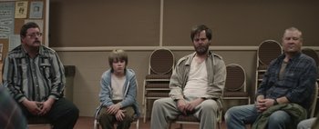 Movie still from “Hesher” (2010), directed by Spencer Susser – A man and a boy sitting on chairs in a room; Medium shot, Over the shoulder angle