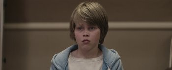 Movie still from “Hesher” (2010), directed by Spencer Susser – A young boy with short brown hair wearing a blue jacket; Close Up shot, Low angle