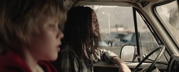 Movie still from “Hesher” (2010), directed by Spencer Susser – A man sitting in a car with a cigarette in his mouth; Close Up shot, Over the shoulder angle