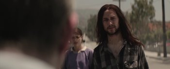Movie still from “Hesher” (2010), directed by Spencer Susser – A man with long brown hair is standing next to a woman; Close Up shot, Over the shoulder angle