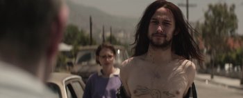Movie still from “Hesher” (2010), directed by Spencer Susser – A man and a woman standing next to each other in a parking lot; Close Up shot, Over the shoulder angle