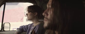 Movie still from “Hesher” (2010), directed by Spencer Susser – A man and a woman sitting next to each other on a train; Close Up shot, Over the shoulder angle