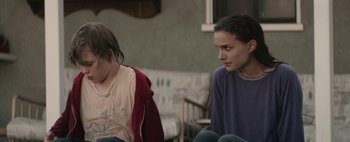 Movie still from “Hesher” (2010), directed by Spencer Susser – Two people sitting on the ground in front of each other; Medium shot, Over the shoulder angle