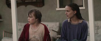 Movie still from “Hesher” (2010), directed by Spencer Susser – Two young people sitting on a porch looking at each other; Close Up shot, Over the shoulder angle