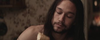 Movie still from “Hesher” (2010), directed by Spencer Susser – A person with long hair eating a sandwich; Close Up shot, Over the shoulder angle