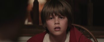 Movie still from “Hesher” (2010), directed by Spencer Susser – A young boy with brown hair wearing a white shirt and a red sweater; Close Up shot, Low angle
