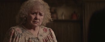 Movie still from “Hesher” (2010), directed by Spencer Susser – An older woman with curly blonde hair wearing a floral dress; Close Up shot, Over the shoulder angle