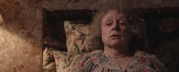 Movie still from “Hesher” (2010), directed by Spencer Susser – An older woman laying in a bed with pillows; Close Up shot, High angle