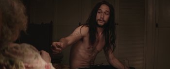 Movie still from “Hesher” (2010), directed by Spencer Susser – A man with long black hair and no shirt; Medium shot, Over the shoulder angle