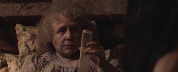 Movie still from “Hesher” (2010), directed by Spencer Susser – An older woman looking at her cell phone; Close Up shot, High angle