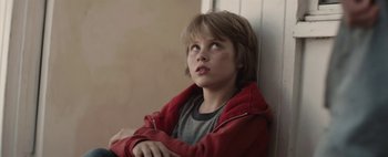 Movie still from “Hesher” (2010), directed by Spencer Susser – A young boy sitting on a ledge looking up; Close Up shot, Low angle