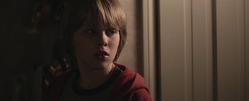 Movie still from “Hesher” (2010), directed by Spencer Susser – A young boy in a red shirt looking at the camera; Close Up shot, Over the shoulder angle