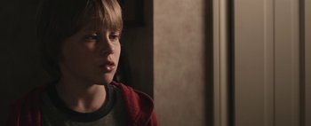 Movie still from “Hesher” (2010), directed by Spencer Susser – A young boy in a red jacket looks at the camera; Close Up shot, Over the shoulder angle