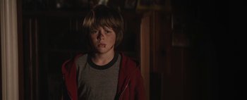 Movie still from “Hesher” (2010), directed by Spencer Susser – A young boy in a red jacket looking at the camera; Close Up shot, Over the shoulder angle