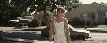 Movie still from “Hesher” (2010), directed by Spencer Susser – A woman in a white outfit is walking down the street; Medium shot, Over the shoulder angle