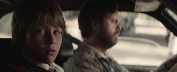 Movie still from “Hesher” (2010), directed by Spencer Susser – A man and a boy sitting in the back of a car; Close Up shot, Over the shoulder angle