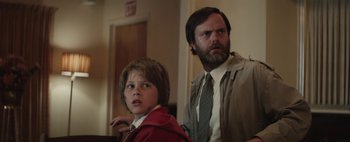 Movie still from “Hesher” (2010), directed by Spencer Susser – A man and a boy standing next to each other in a room; Medium shot, Low angle